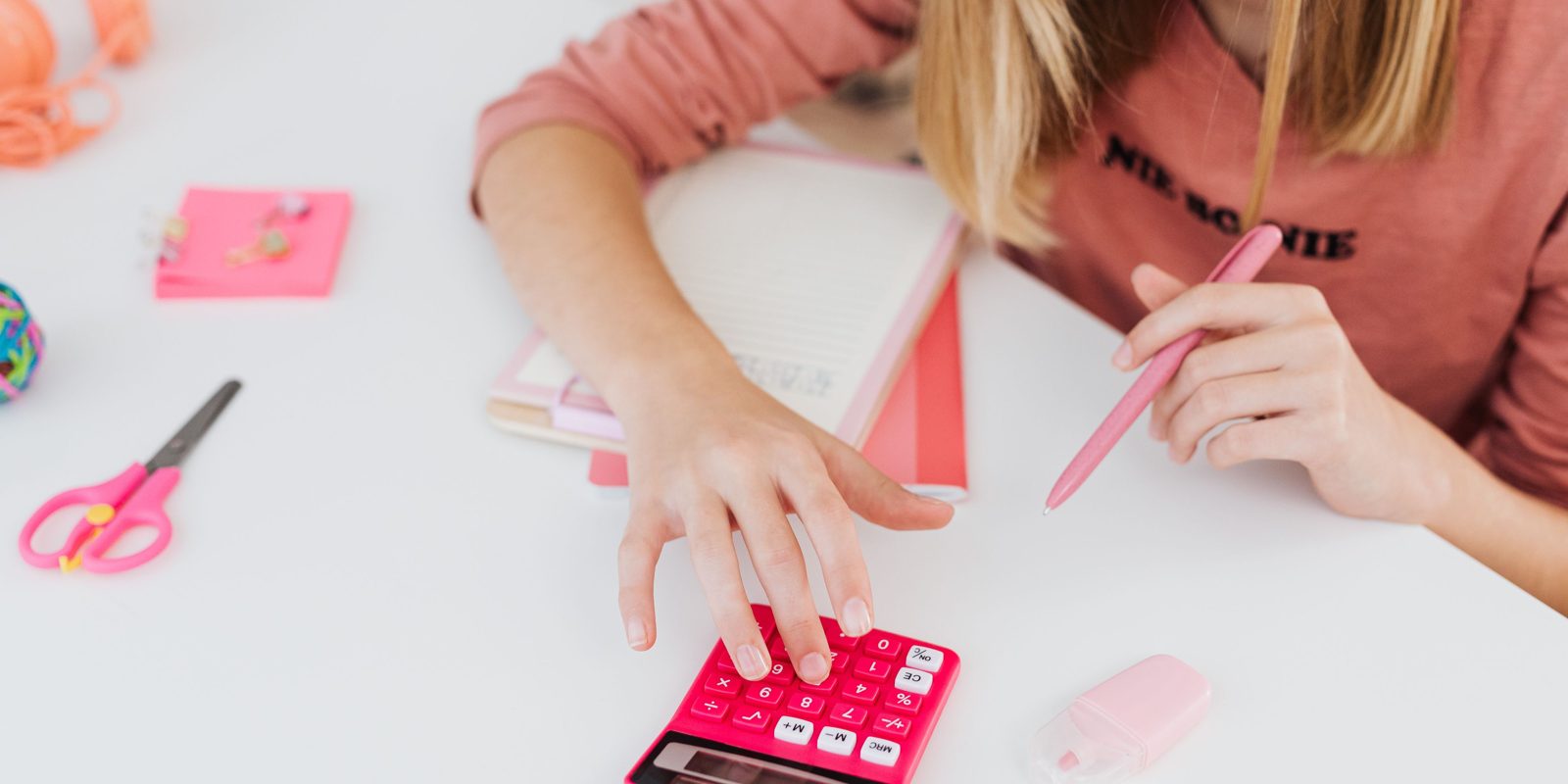 Une étudiante compare ses relevés à côté de sa calculatrice